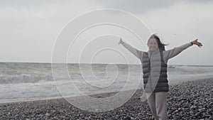 Young woman wearing a warm clothes on the beach in Turkey during a storm.