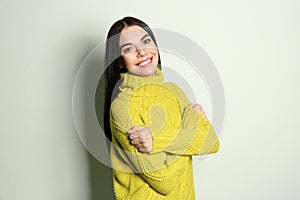 Young woman wearing warm sweater on background. Winter season