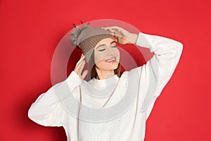 Young woman wearing warm sweater and hat on background. Winter season