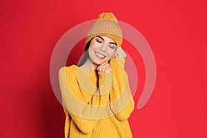 Young woman wearing warm sweater and hat on background. Winter season