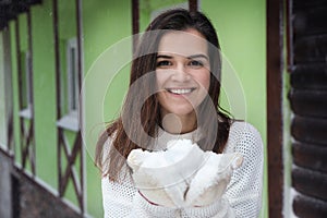 Young woman wearing warm sweater and mittens  on snowy day. Winter season