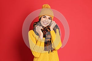 Young woman wearing warm sweater, scarf and hat on background. Winter season