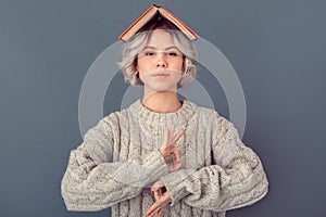 Young woman in a woolen sweater on grey wall winter concept meditating