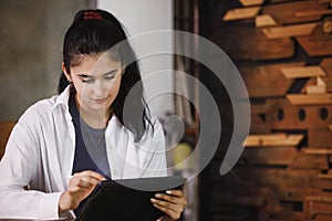 Young woman wearing white suit working using tablet at table company. creative female using online chatting on tablet at workplace