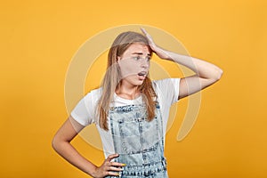 Young woman wearing white t-shirt, over orange background shows emotions