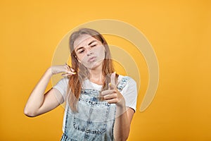 Young woman wearing white t-shirt, over orange background shows emotions