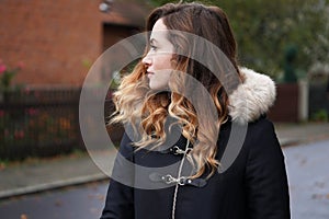 Young woman wearing winter coat on suburban street