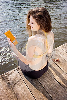 Young woman wearing in yellow swimsuit with sun shape on the shoulder on the beach