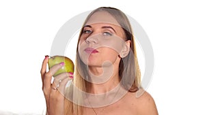 Young woman wears red lipstick and has her hair down, and brushed, eating a big, juicy pear. healthy food - strong