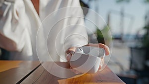 Young woman wears wireless earphones. Clothe-up. Hands holding Airpods case in hand, Apple wearable earphones.