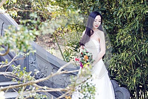 A young woman wedding photo/portrait sit on an ancient old bridge in Shanghai shui bo parkpark of water