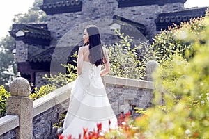 A young woman wedding photo/portrait stand on a ancient old bridge