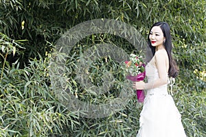A young woman wedding photo/portrait stand by bamboo in Shanghai shui bo parkpark of water