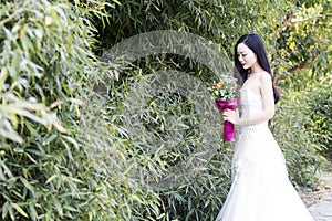 A young woman wedding photo/portrait stand by bamboos