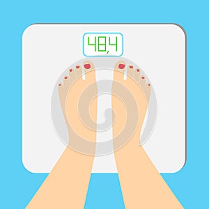 The young woman is weighed on scales. female feet with a pedicure are on an electronic balance photo