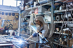 young woman welding in workshop