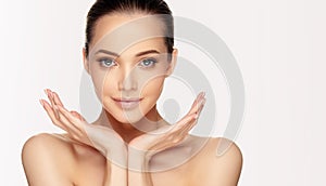 Young woman with well groomed skin of the face is holding graceful hands in a symmetrical positi.Facial treatment and cosmetology.