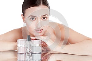 Young woman with a well-groomed skin near the creams cosmetics.