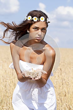 Young woman in a wheat golden field