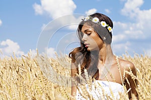 Young woman in a wheat golden field