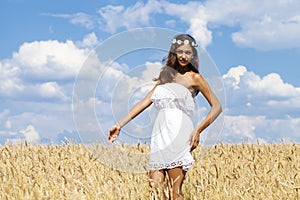 Young woman in a wheat golden field