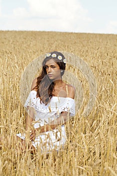 Young woman in a wheat golden field