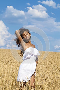 Young woman in a wheat golden field