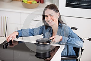 young woman in wheelchair cooking