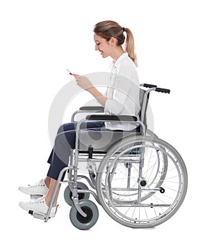 Young woman in wheelchair using mobile phone