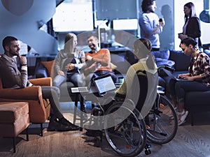 Young woman in wheelchair working on laptop at office. Getting an education at home concept