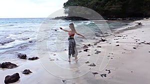 Young woman whirls on the beach in Bali
