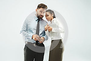 The young woman whispering a secret behind her hand over white background