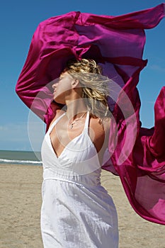 Young woman in white on beach with red fluttering