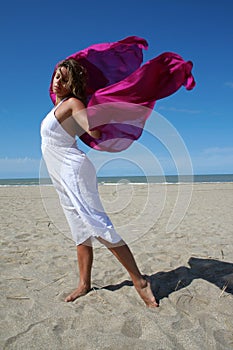 Young woman in white on beach with red fluttering