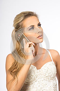 Young woman in white blouse. Blonde girl is talking on the cell phone. Female with telephone. Businesswoman calls with smartphone.