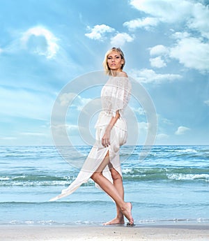 A young woman in a white dress on a beach background