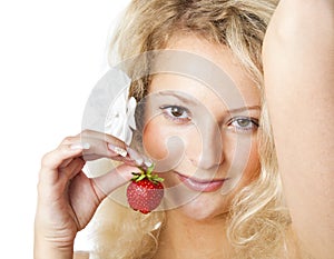 Young woman in white dress eating strawberries