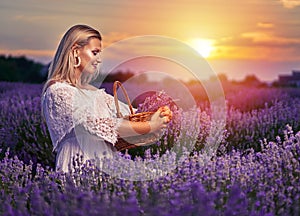 Young woman in white dress in a lavender field at sunset