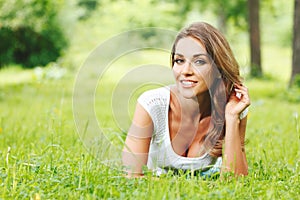 young woman in white dress lying on grass