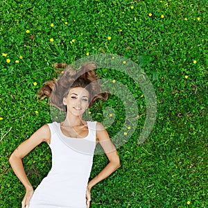 Young woman in white dress lying on grass