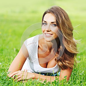 Young woman in white dress lying on grass
