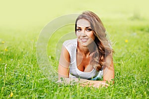 Young woman in white dress lying on grass