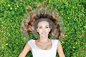 Young woman in white dress lying on grass