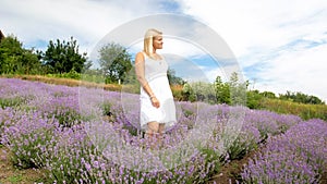 Young woman in white dress posing in lavender field