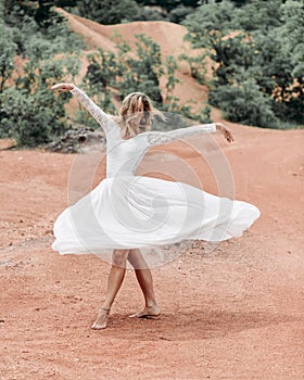 Young woman in white dress spinning