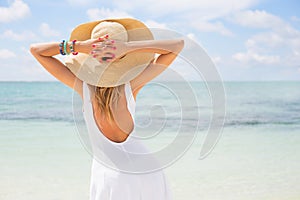 Mujer joven en blanco ropa a paja un sombrero sobre el Playa 
