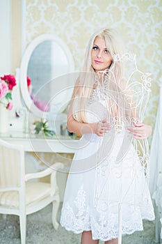 Young woman in white dress touches white hanger in photo