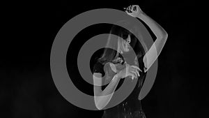 Young woman in a white empty cloud of flour in a black background