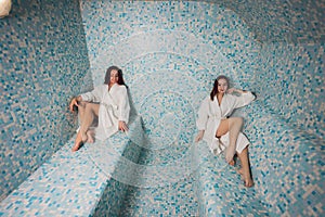 Young woman in white foam in a beautiful hamam of mosaic.