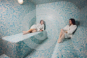 Young woman in white foam in a beautiful hamam of mosaic.